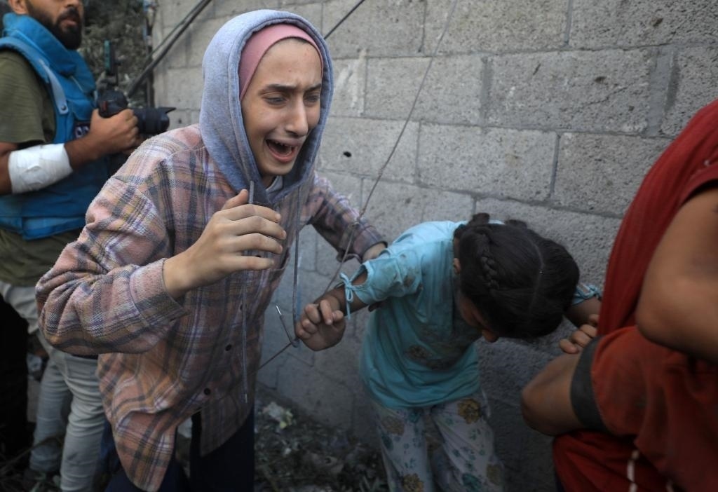 11月6日，人們從加沙地帶中部地區(qū)一處被炸難民營逃離。新華社發(fā)（亞西爾·庫迪攝）