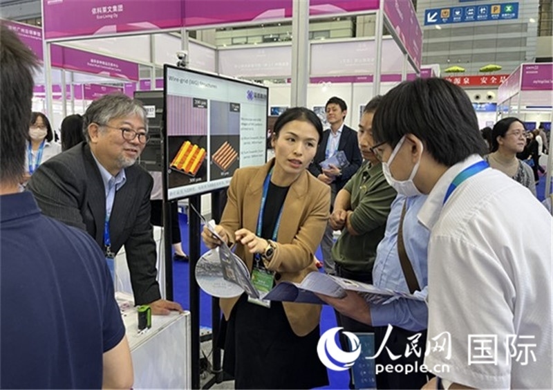 工作人員向參觀者介紹超級(jí)噴墨技術(shù)。（人民網(wǎng)記者 陳思攝）