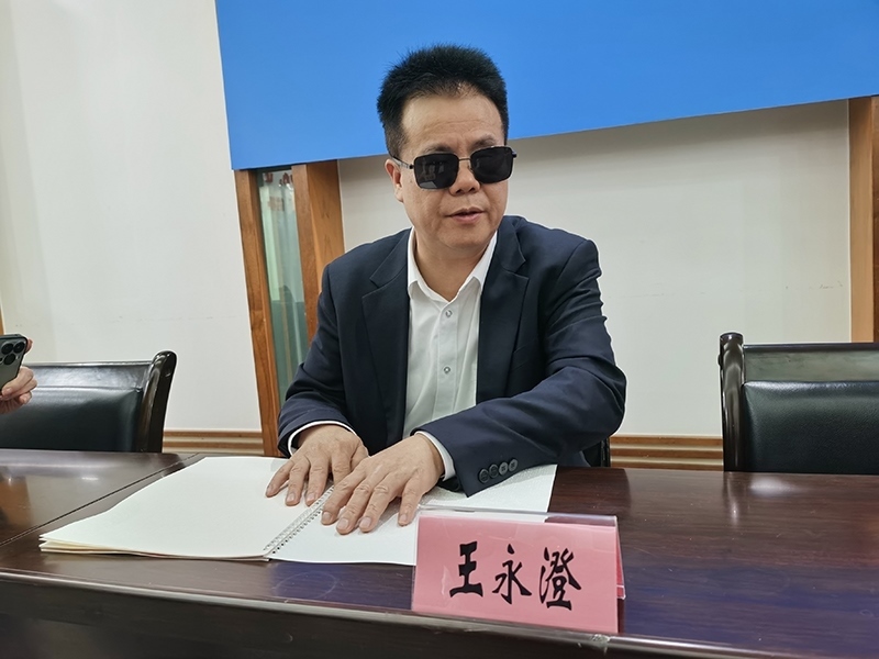 全國人大代表王永澄正在閱讀盲文版代表建議答復(fù)。本報(bào)記者 張 璁?dāng)z