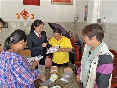  圖⑤：龍圩區(qū)法院法官到群眾家中開展法治宣傳。資料圖片