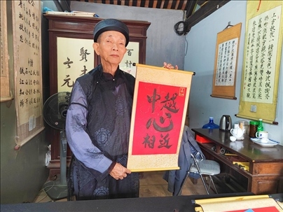 越南首都河內(nèi)文廟內(nèi)，阮明珠展示“中越心相近”書法作品。