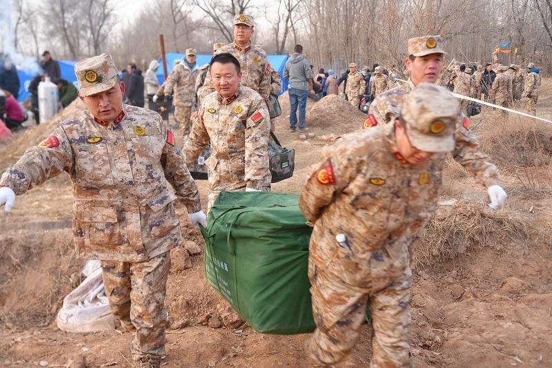 救援人員正在現場緊急搬運物資。賀勇攝。