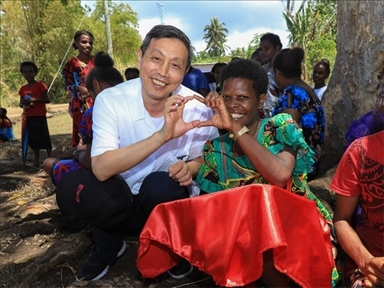 2023年12月18日，中國駐瓦努阿圖大使李名剛和前來觀看瓦努阿圖公路項目二期馬勒庫拉段移交儀式的當?shù)鼐用窈嫌?。人民網(wǎng) 賀吉攝