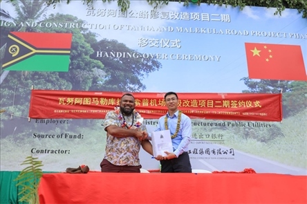 2023年12月18日，瓦努阿圖基礎(chǔ)設施和公共事業(yè)部長瑞克·查馬克·馬赫（左）和中土南太公司總經(jīng)理梁慶（右）在馬勒庫拉諾索普機場升級改造二期項目的簽約儀式上握手。人民網(wǎng) 賀吉攝
