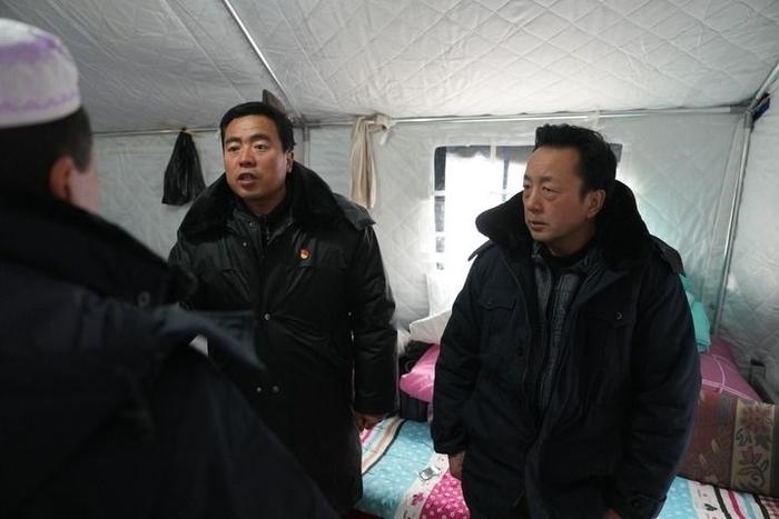 2023年12月22日，積石山縣大河家鎮(zhèn)大河村黨支部書記馬成忠（右二）在帳篷里和受災(zāi)群眾交流。新華社記者 陳斌 攝