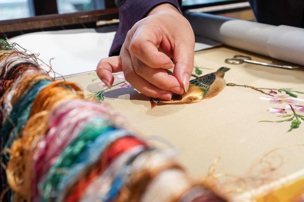 △2023年7月6日，盧建英在江蘇蘇州平江路的工作室內(nèi)刺繡。