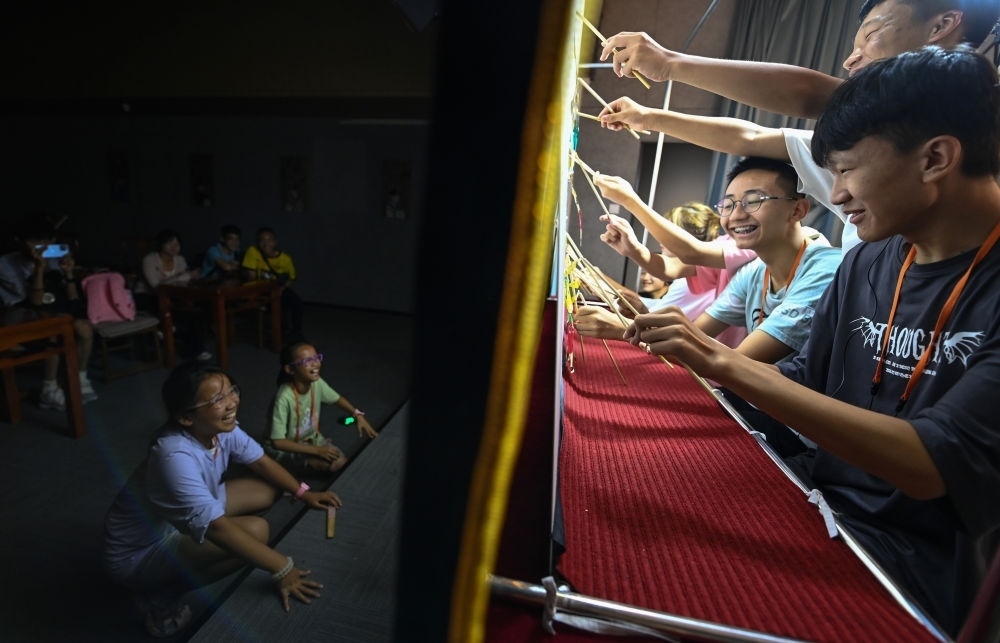 2023年8月8日，進(jìn)行暑期研學(xué)的學(xué)生在位于陜西省西安市的中國(guó)秦腔藝術(shù)博物館體驗(yàn)皮影戲演出。新華社記者 鄒競(jìng)一 攝