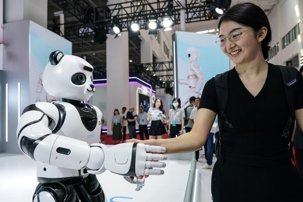 2023年8月16日，一名女士在北京舉辦的2023世界機器人大會現場與智能機器人握手。新華社記者彭子洋攝