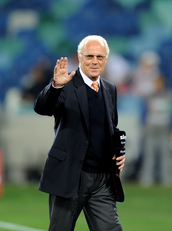 這是2010年7月7日，在南非德班舉行的2010年足球世界杯德國(guó)隊(duì)對(duì)陣西班牙隊(duì)的半決賽前，貝肯鮑爾接受電視臺(tái)采訪時(shí)和友人打招呼。新華社記者 王毓國(guó) 攝