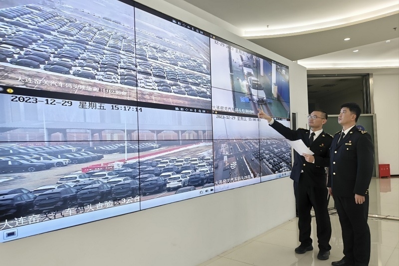 海關(guān)關(guān)員視頻巡查出口汽車場地。李進(jìn)攝