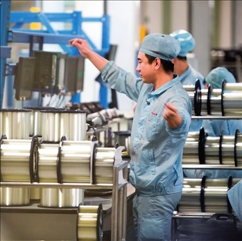 在位于武漢的長飛光纖光纜股份有限公司光纖生產(chǎn)車間內(nèi)，工作人員對光纖進行檢測（資料圖片）。肖藝九攝/本刊