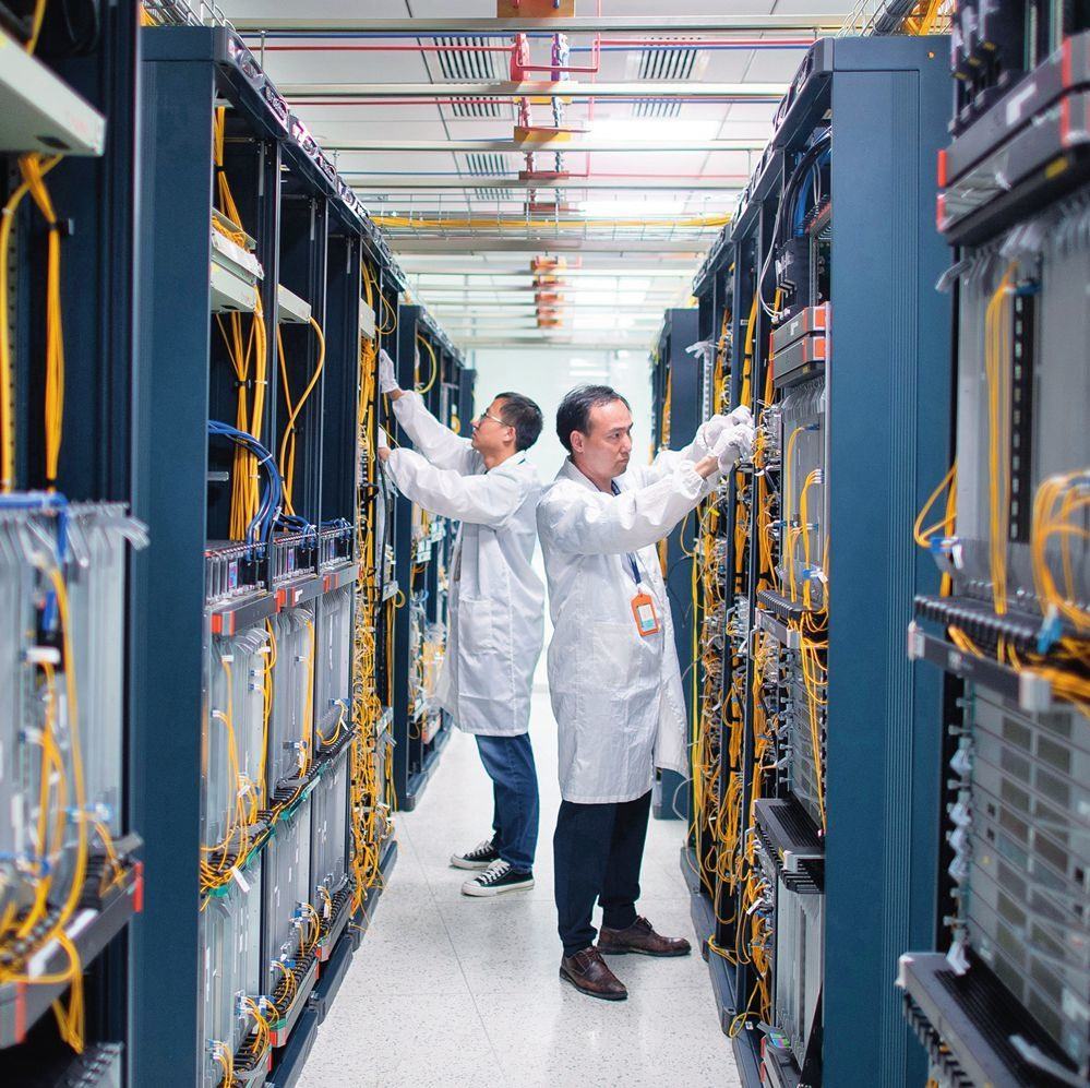 在位于武漢中國光谷的光電器件研發(fā)制造商——武漢光迅科技股份有限公司生產(chǎn)車間內(nèi)，技術(shù)人員在光模塊生產(chǎn)線作業(yè)（2023年4月11日攝）。程敏攝/本刊