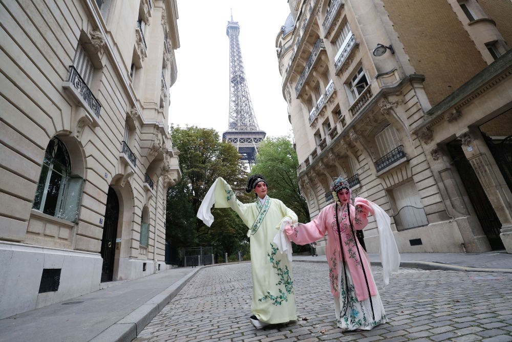 2023年9月13日，江蘇省演藝集團(tuán)昆劇院院長(zhǎng)施夏明（左）和江蘇省演藝集團(tuán)昆劇院國(guó)家一級(jí)演員孔愛(ài)萍在法國(guó)巴黎埃菲爾鐵塔附近參加昆曲快閃。新華社記者 高靜 攝