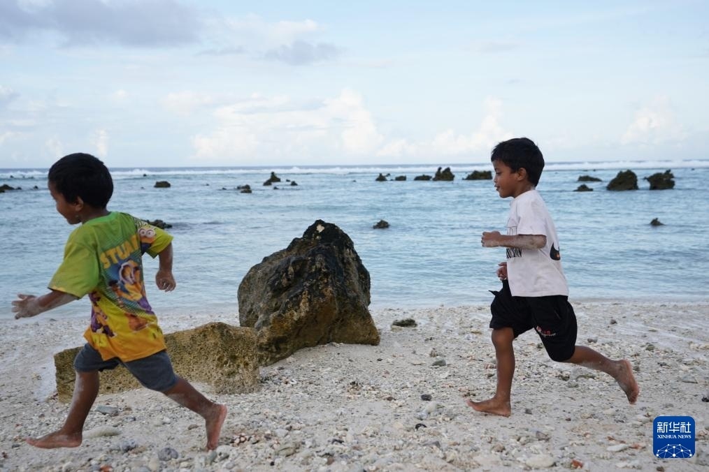 1月20日，兒童在瑙魯海邊嬉戲。新華社記者 王申 攝