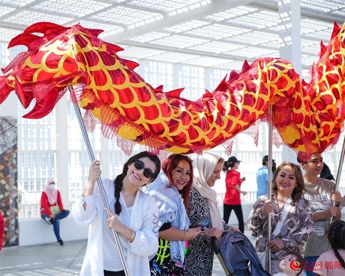 游客體驗(yàn)舞龍。 人民網(wǎng) 塔里克·易卜拉欣攝