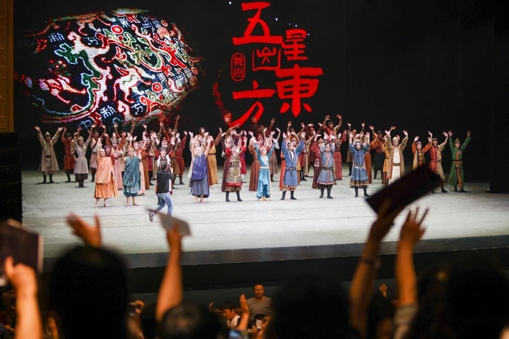 2023年7月31日，新疆和田地區(qū)新玉歌舞團(tuán)在烏魯木齊京劇院演出舞劇《五星出東方》后和觀眾互相揮手致意。這場(chǎng)演出是第六屆中國新疆國際民族舞蹈節(jié)的參演劇目之一，曾榮獲國家“文華獎(jiǎng)”等。新華社記者 郝昭 攝