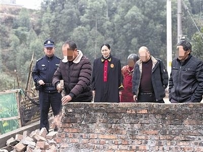  圖③：庭審結束后，在法官的見證下，陳某在院壩邊重新開鑿一條通道。