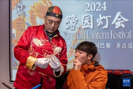 1月28日，在上海豫園舉行的民俗活動上，美國馬斯卡廷中學(xué)學(xué)生在非遺傳承人的指導(dǎo)下吹糖偶。 新華社記者 王翔 攝