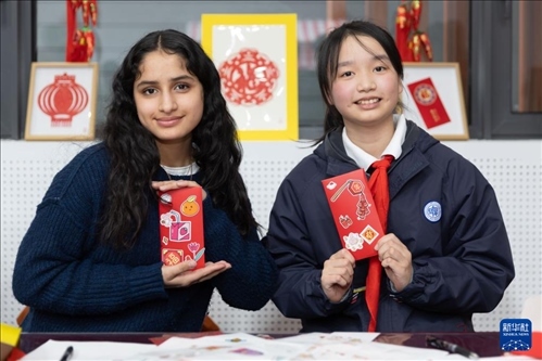 1月28日，美國馬斯卡廷中學(xué)學(xué)生（左）和復(fù)旦大學(xué)第二附屬學(xué)校學(xué)生展示互相送出的寫有寄語祝福的紅包。 新華社記者 王翔 攝