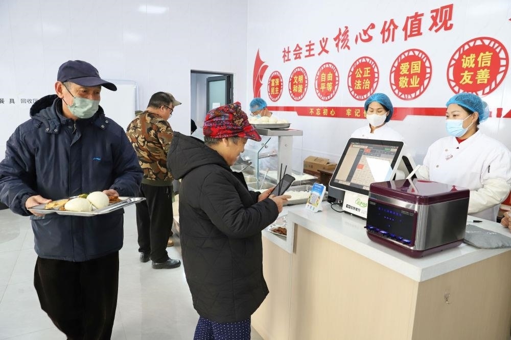 △2024年2月1日，市民在河北涿州市雙塔街道永濟秀園小區(qū)便民食堂內(nèi)購買午餐。