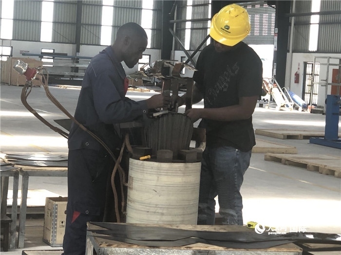 經(jīng)貿(mào)合作區(qū)廠房內(nèi)，當?shù)毓と苏诰o張作業(yè)。人民網(wǎng)記者 黃培昭攝