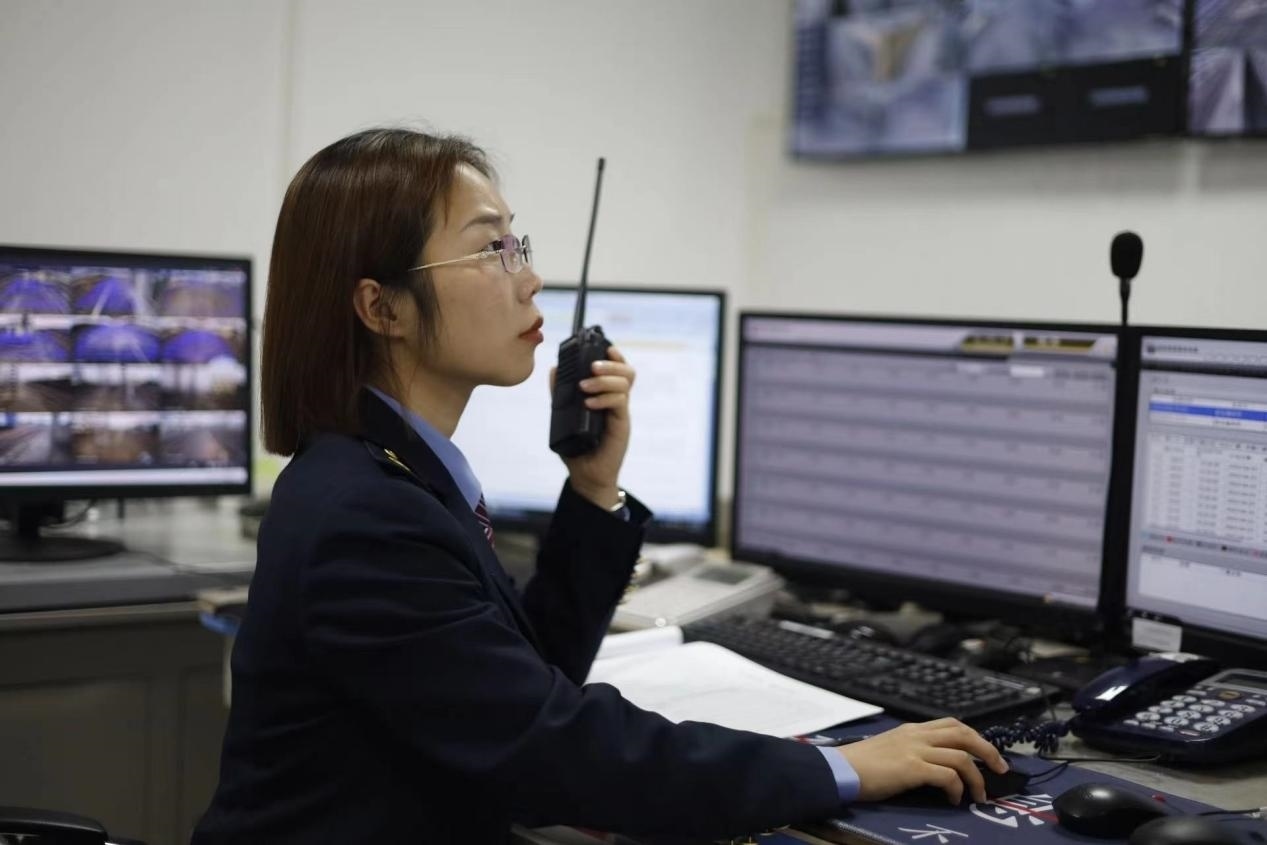 張華正在使用對講機(jī)溝通客運(yùn)工作情況。蔡紫妍攝