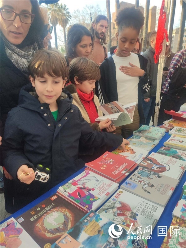 印刷精美的中國傳統(tǒng)文化叢書吸引了小游客的注意。人民網記者鄭彬攝