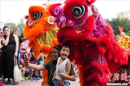 圖為舞獅表演吸引民眾合影。張興龍攝