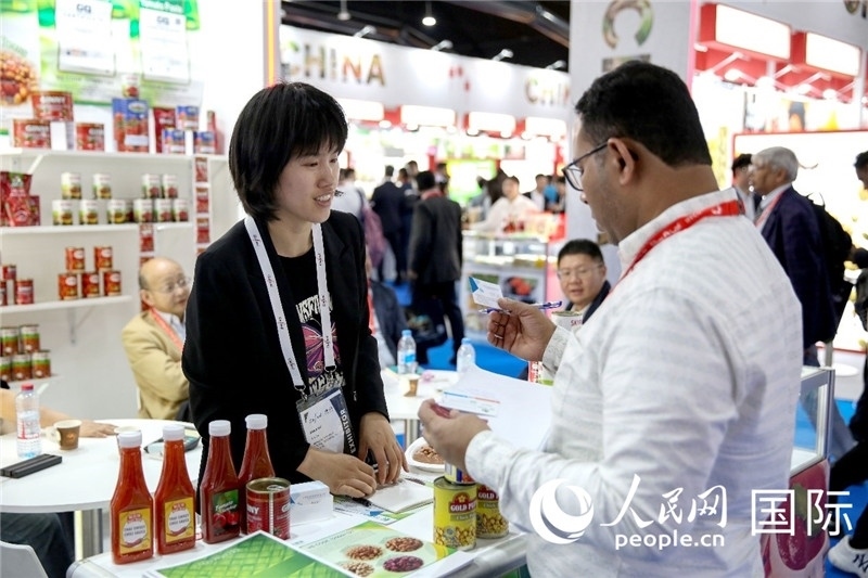 圖為中國參展企業(yè)代表與采購商交流。人民網(wǎng) 塔里克·易卜拉欣攝