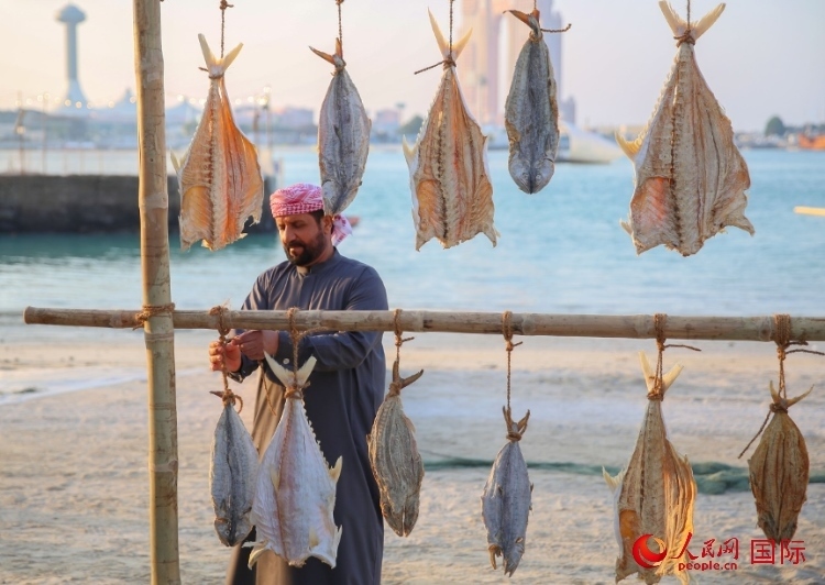  手工藝者展示如何晾曬魚干。人民網(wǎng) 塔里克·易卜拉欣攝