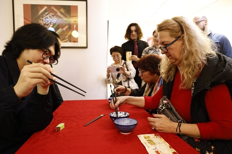 羅馬尼亞觀眾體驗(yàn)用筷子夾花生。中國文化中心供圖