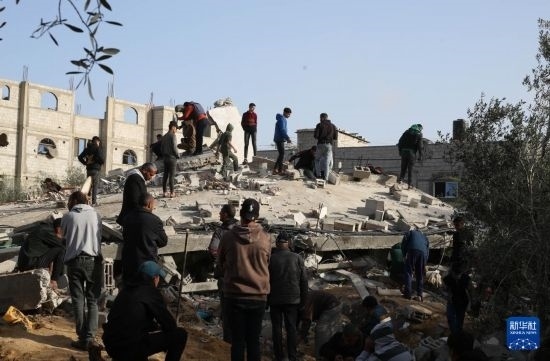  3月3日，在加沙地帶南部城市拉法，人們查看被以軍空襲破壞的建筑。新華社發(fā)（哈立德·奧馬爾攝）