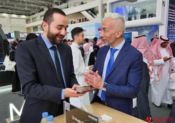 兩名觀眾在榮耀手機(jī)展臺(tái)前交流。人民網(wǎng)記者 管克江攝