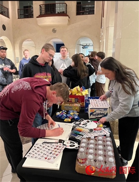 學(xué)生們出發(fā)前紛紛在留言簿留言。人民網(wǎng)記者 鄧圩攝