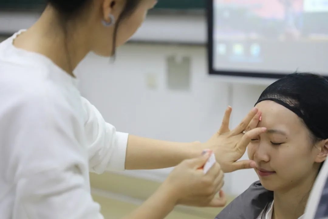 課堂上，一名學(xué)生在體驗(yàn)上戲妝。學(xué)校供圖