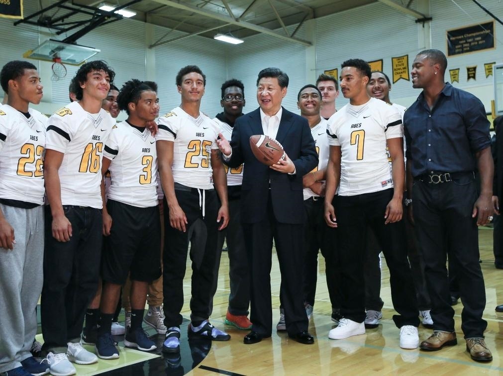 2015年9月23日，國(guó)家主席習(xí)近平參觀美國(guó)塔科馬市林肯中學(xué)。這是習(xí)近平在學(xué)校體育館，同上橄欖球訓(xùn)練課的學(xué)生們親切交談。新華社記者 蘭紅光 攝