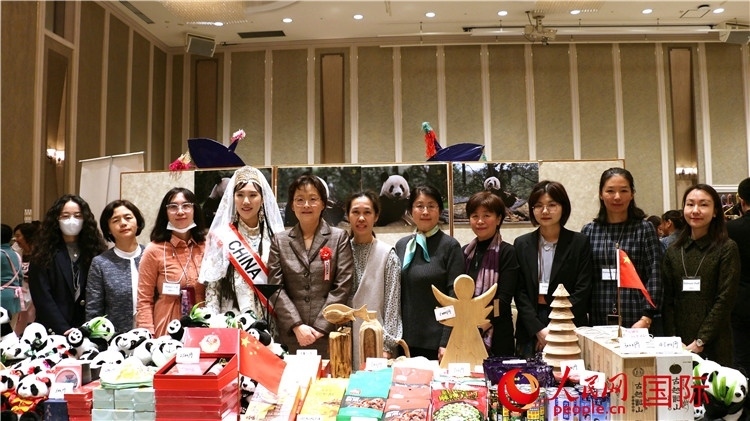 中國(guó)駐日本大使吳江浩夫人丁玥（左五）與使館人員在展位前合影留念。人民網(wǎng) 許可攝