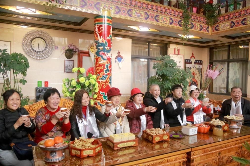 游客們?nèi)胱∶袼藓?，舉杯共飲酥油茶。新華社記者 邱星翔 攝
