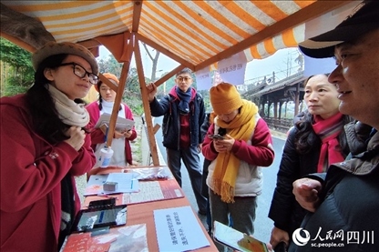 1月6日，“2024成都蒲江柑甜采摘節(jié)”上，記者見到了小萌（左一）和許多年輕人忙著做訪客接待、現(xiàn)場布置、票務(wù)核對、采摘服務(wù)等工作。人民網(wǎng)記者朱虹攝