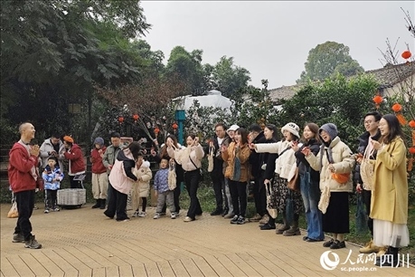 葉科（左一）給前來參與活動的“柑爸柑媽”介紹生態(tài)種植果。人民網(wǎng)記者朱虹攝