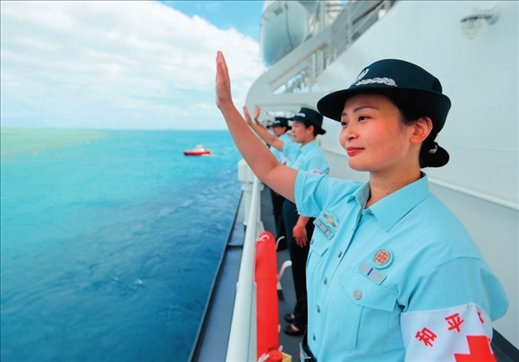 中國海軍“和平方舟”號醫(yī)院船結(jié)束訪問湯加時，任務(wù)官兵中的文職人員向歡送人群揮手告別（2023年8月4日攝）。徐巍攝/本刊