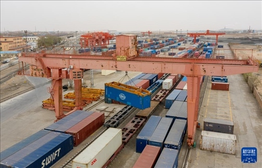 4月21日，二連浩特鐵路口岸龍門吊吊裝中歐班列集裝箱（無(wú)人機(jī)照片）。 新華社發(fā)（張海峰攝）