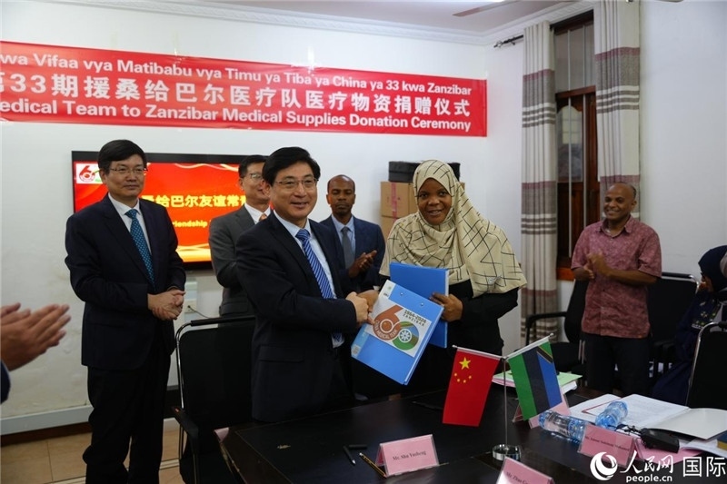 江蘇省蘇北人民醫(yī)院黨委書記束余聲與桑衛(wèi)生部首席秘書哈比巴交換捐贈(zèng)書。中國援桑醫(yī)療隊(duì)供圖