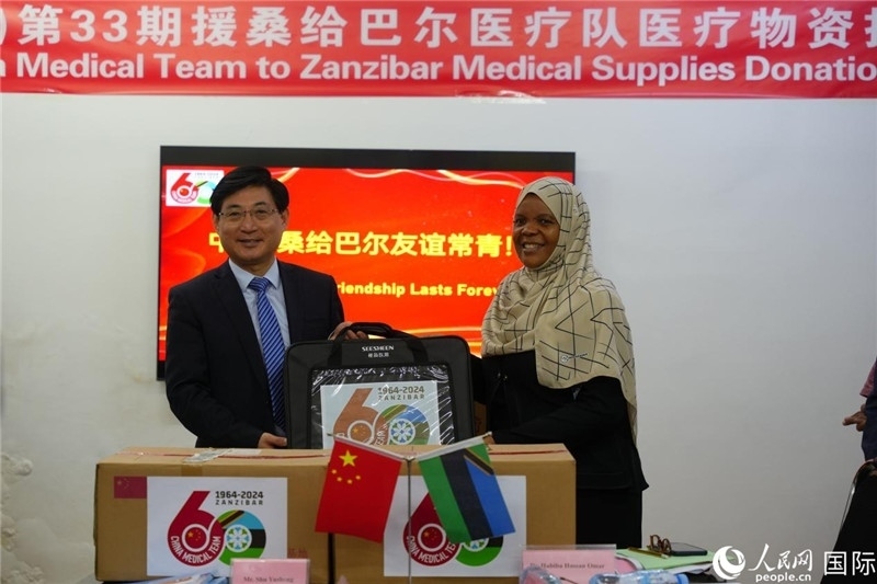 江蘇省蘇北人民醫(yī)院黨委書記束余聲捐贈(zèng)物資與桑衛(wèi)生部首席秘書哈比巴。中國援桑醫(yī)療隊(duì)供圖