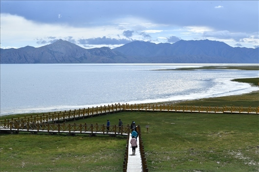 △ 游客行走在青海瑪多縣冬格措納湖畔的木棧道上。
