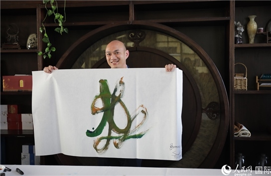 老撾駐華大使館三秘明君參加《五百筆·瀾湄合作》集體藝術(shù)創(chuàng)作。人民網(wǎng)王婧攝。