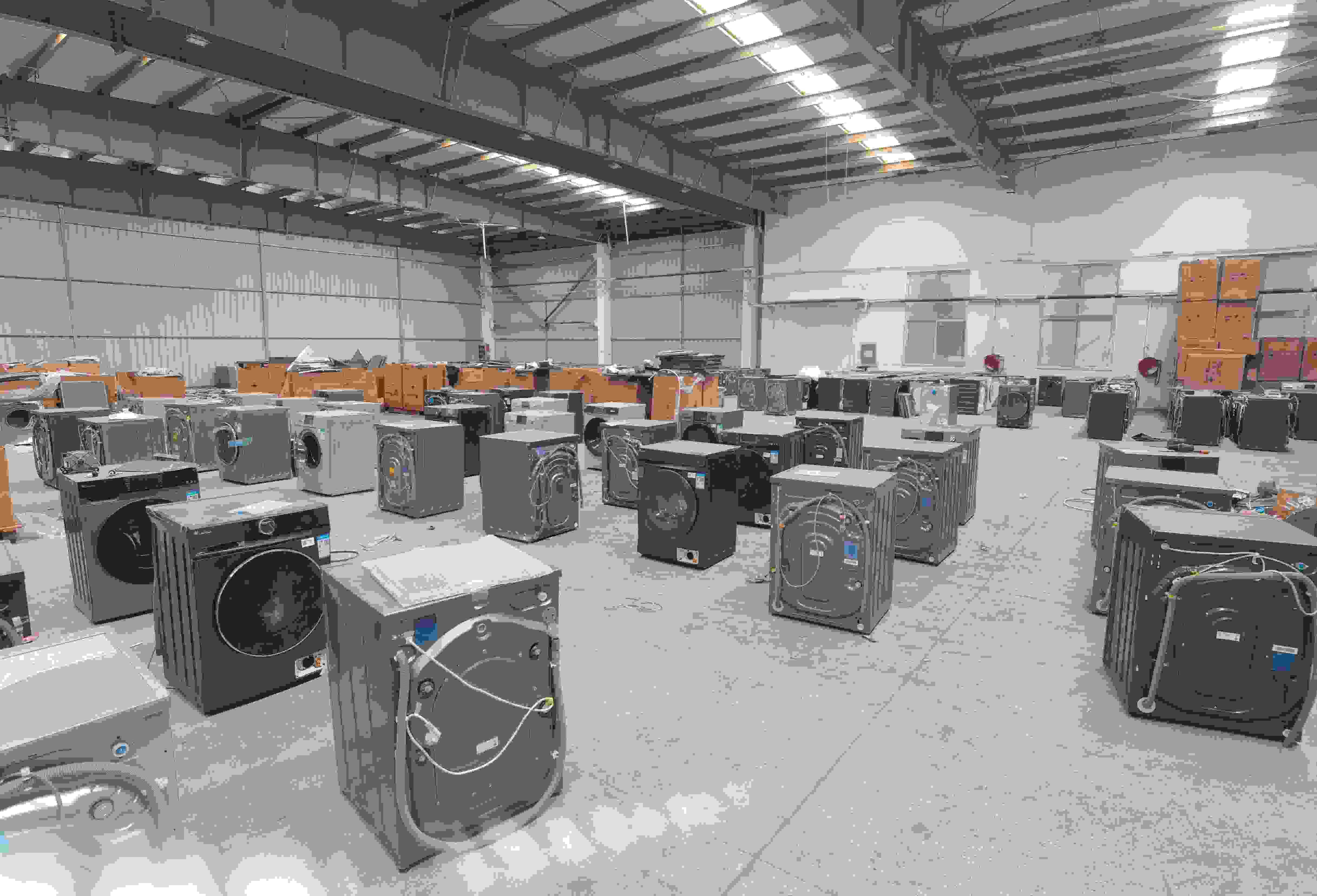 專(zhuān)案組民警查扣涉案場(chǎng)所及假冒知名品牌洗衣機(jī)。巨野警方供圖