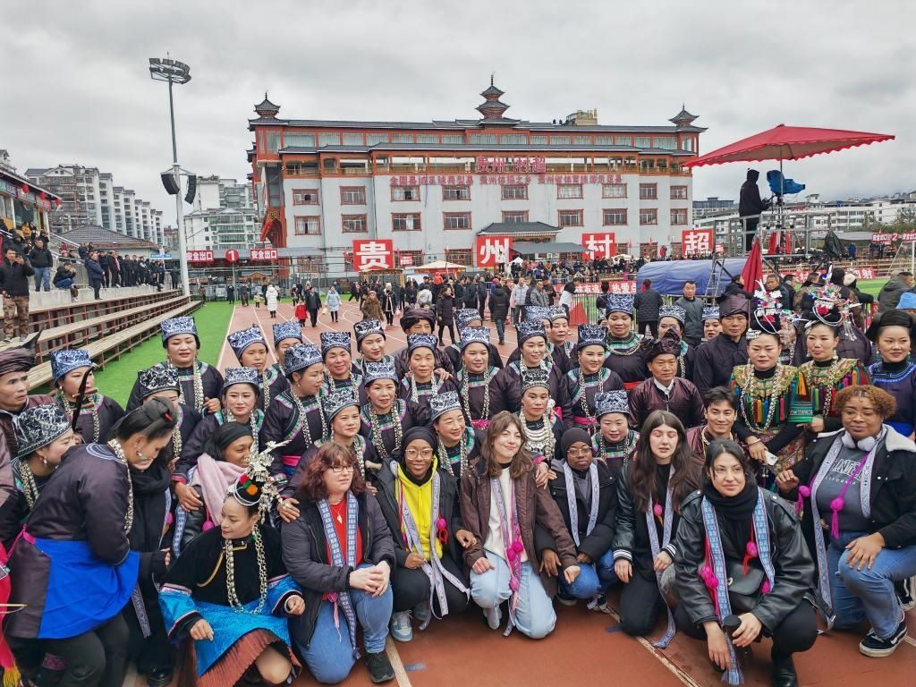 法國青年在“村超”賽場邊與參加表演的村民合影。新華社記者 羅羽 攝