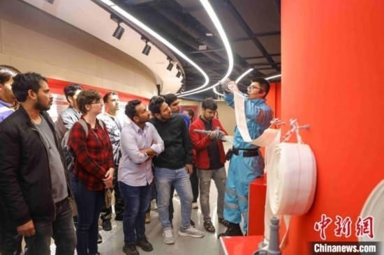 5月9日，工作人員指導(dǎo)留學(xué)生正確使用消防水帶。張鷹 攝