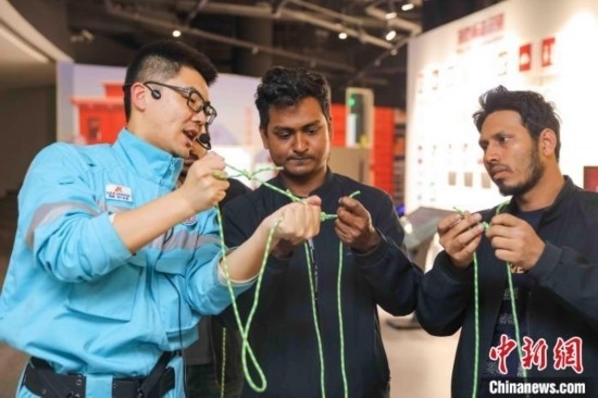 5月9日，工作人員指導(dǎo)留學(xué)生學(xué)習(xí)打繩結(jié)。張鷹 攝